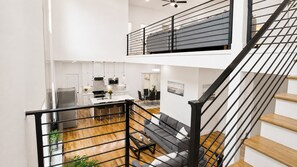 A modern interior with a staircase, a kitchen, and a dining area.