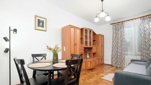Un coin repas comprenant une table ronde, des chaises noires, un lampadaire et un meuble avec des portes en verre.
