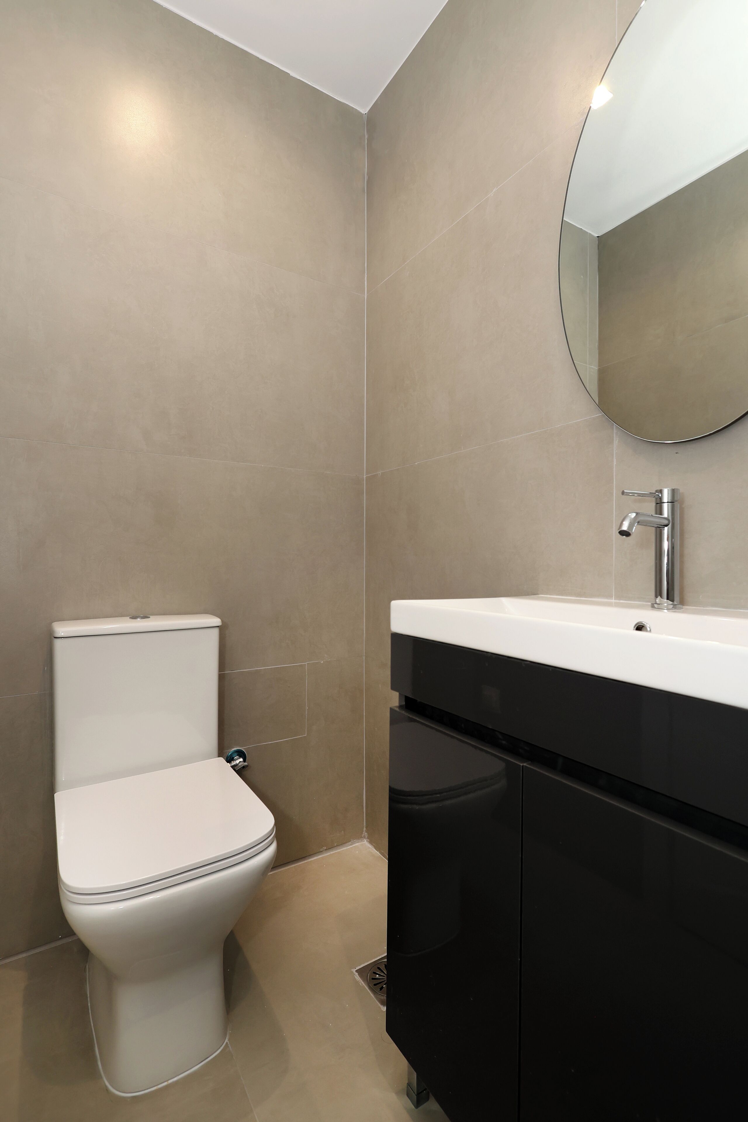 A modern bathroom with a toilet, sink, and mirror.