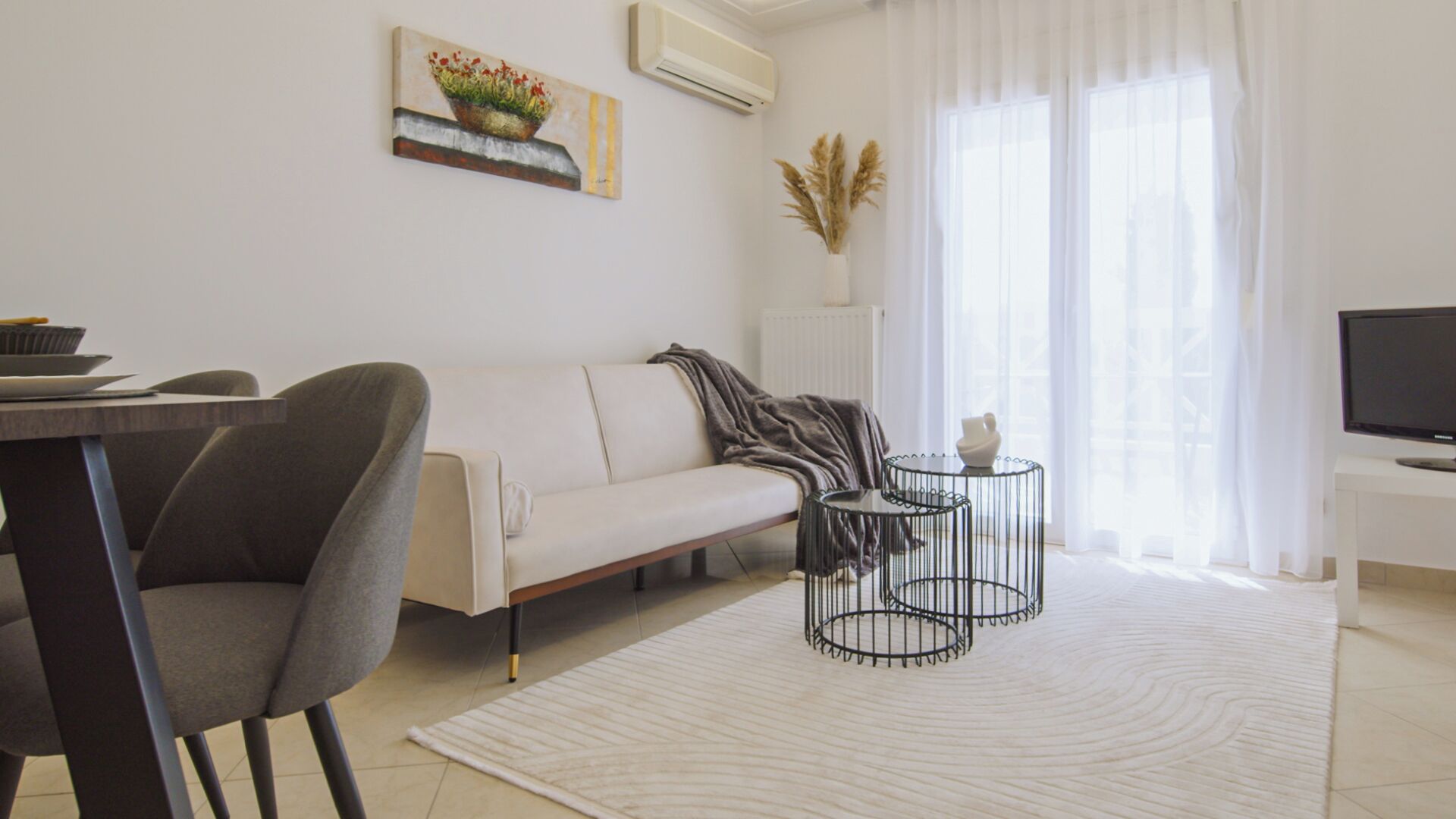 Een moderne woonkamer met een bank, een eettafel en een televisie.