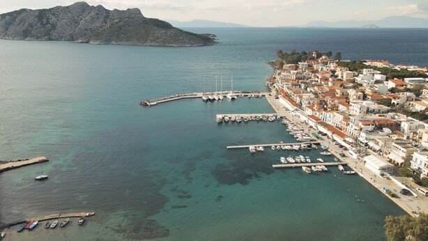 A coastal town with a marina, boats docked, and buildings along the waterfront. - Perdika Residences (Aegina)