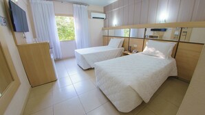 A hotel room with two beds, a desk, a mirror, and an air conditioning unit. - One Unit | Breakfast Included | Near Bird Park (Parana)