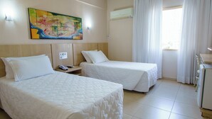 A hotel room with two beds, a painting on the wall, a phone on the nightstand, and a window with curtains. - Twin Room | Free Breakfast | Near Iguazu National Park (Foz do Iguaçu)