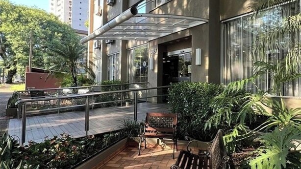 A building entrance with a covered walkway, outdoor seating, and potted plants. - One Unit w/ Multiple Rooms | Free Breakfast | Near Bird Park (Foz do Iguaçu)
