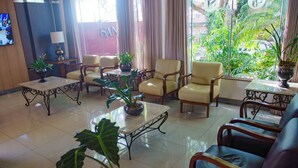 A hotel lobby with a seating area, a television, and potted plants. - Three Couple Rooms | Breakfast Included | Near Iguazu Waterfalls (Parana)