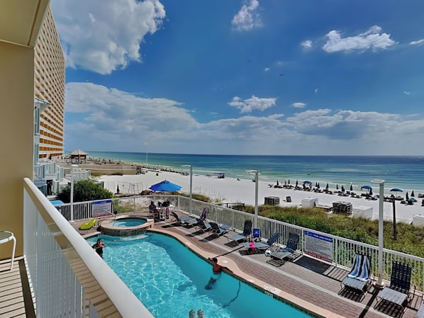 A pool area with a view of the beach and ocean.