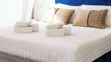 Svit Deluxe - balkong - utsikt mot staden | VÀrdeförvaringsskÄp pÄ rummet och arbetsyta för laptop