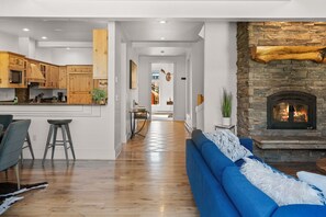 A modern kitchen with wooden cabinets and a stone fireplace.