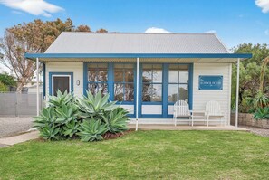 A small building with a blue door, large windows, and a sign that reads 'The School House.'