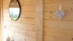 A wooden wall with a mirror and a heart-shaped decoration. - Unique Barrel So'Happy - A Gourmet Getaway (Sevremont)