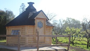 A log cabin with a hexagonal window, a door, and a chimney. - Unique Barrel So'Happy - A Gourmet Getaway (Sevremont)