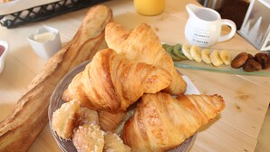 A breakfast setting with croissants, a coffee pot, and a juice pitcher. - Unique Barrel So'Happy - A Gourmet Getaway (Sevremont)