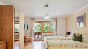 A bedroom with a bed, a desk, a chair, a radiator, a window, and a ceiling fan. - Holiday Apartment 'Bergfranzenhof' with Shared Terrace, Balcony and Wi-Fi (Oppenau)