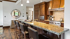A modern kitchen with granite countertops, wooden cabinets, and stainless steel appliances. - Arrowleaf Lodge at Deer Valley Resort - Three Bedroom Residence #203 3 Condo (Park City)