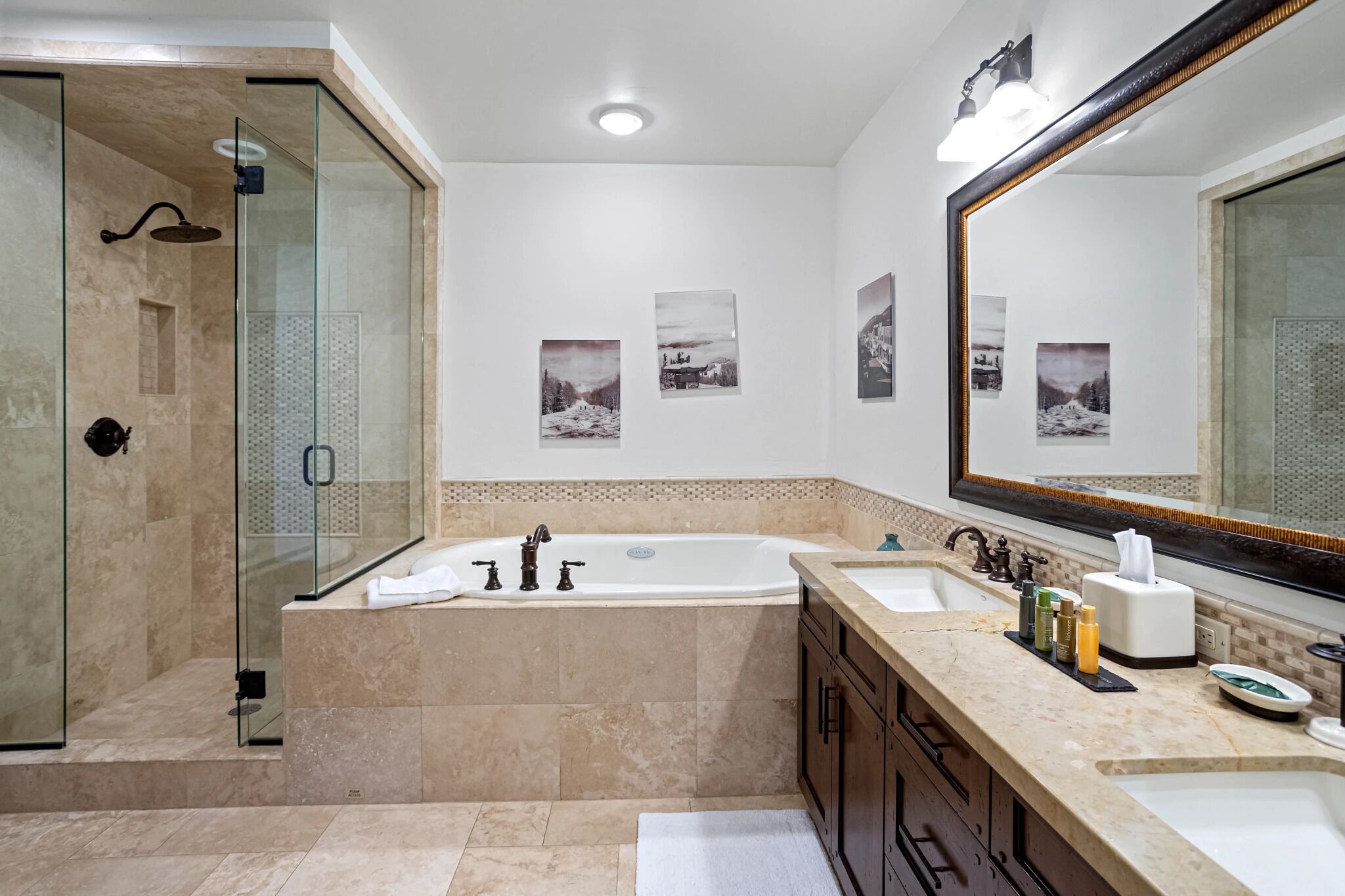 A modern bathroom with a glass-enclosed shower, a double sink vanity, and a large mirror.