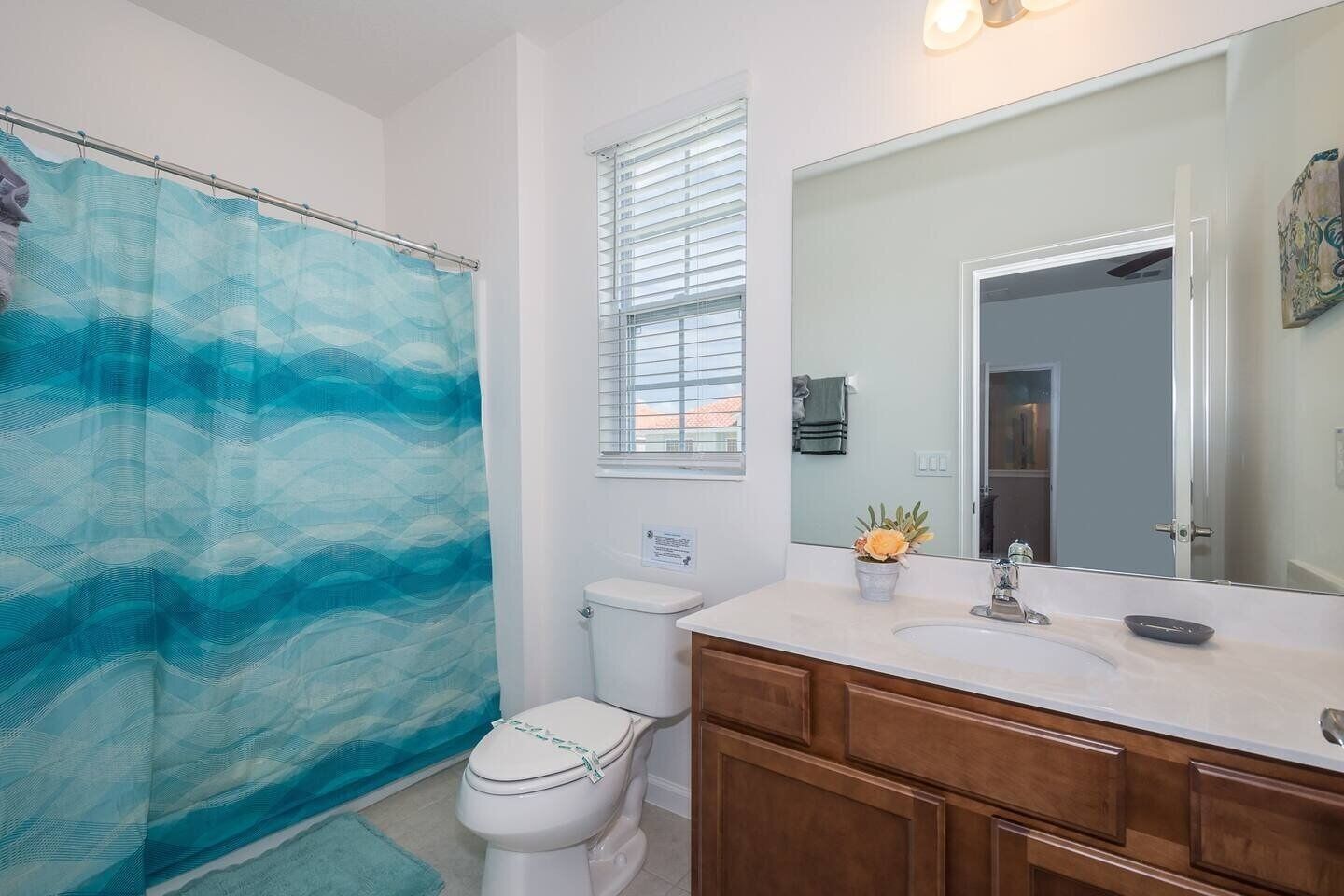 Un bagno con tenda doccia, toilette, lavandino e mobile lavabo.