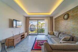 Suite estándar, 1 cama de matrimonio, balcón, vistas al mar | Zona de estar | Smart TV de 50 pulgadas con canales por cable