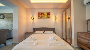 A hotel room with a bed, bedside tables, a clock on the wall, a painting, and a wardrobe.