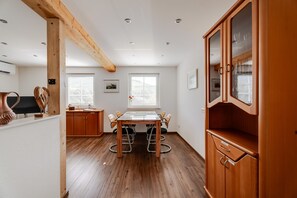 Una cocina moderna con armarios de madera, una mesa de comedor y un amplio ventanal.