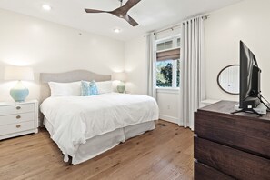 A bedroom with a bed, bedside tables, a ceiling fan, a window with curtains, and a TV on a dresser. - Seagrove "Beachbound" 1BR, Sleeps 4, Gulf Views, Private Beach Access (Santa Rosa Beach)