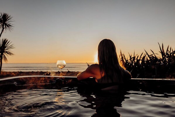 Une personne dans une piscine, avec une vue sur le coucher de soleil.