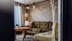 Ein Wohnzimmer mit einem grünen Sofa, einem runden Couchtisch und einer Wand mit Fischdekorationen.