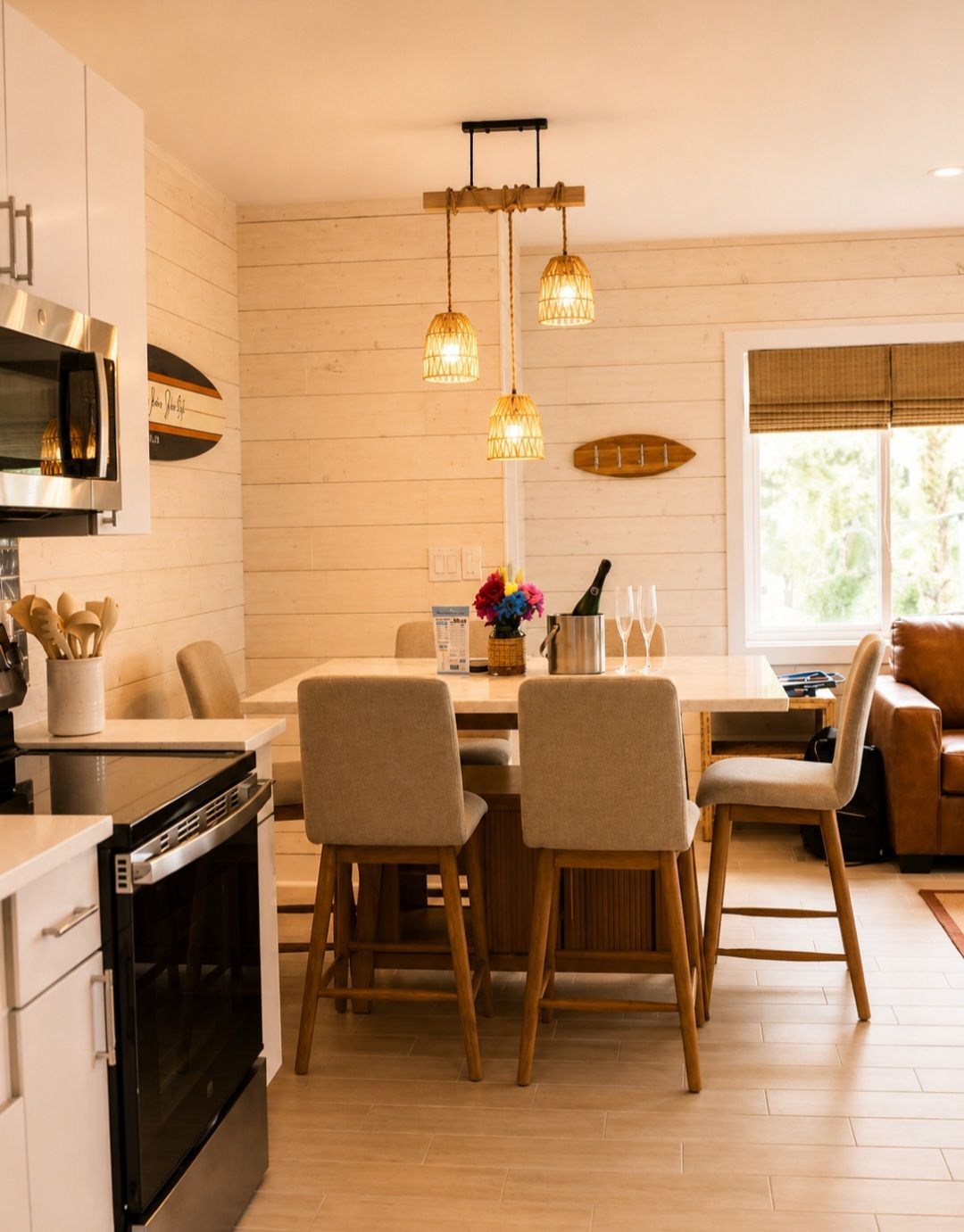 Una cocina moderna con comedor, piso de madera e iluminación colgante.
