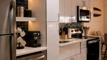 A modern kitchen with stainless steel appliances, a coffee machine, and a microwave.