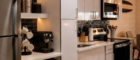 A modern kitchen with stainless steel appliances, a coffee machine, and a microwave.
