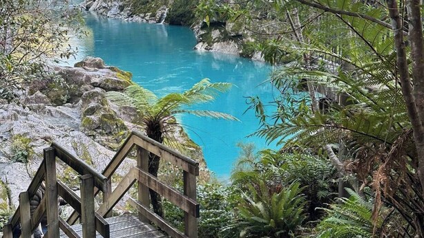 A wooden staircase leading to a turquoise pool surrounded by lush greenery and rocks. - Kowhai Cabin - Serene Scandi Escape in Hokitika (Hokitika)