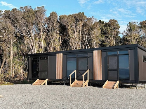 Perched on a peaceful ridge above the Tasman Sea, Sola Ridge offers a modern yet cozy retreat with breathtaking views.