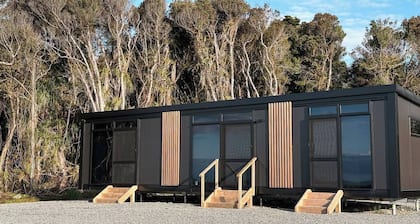 Perched on a peaceful ridge above the Tasman Sea, Sola Ridge offers a modern yet cozy retreat with breathtaking views.