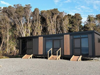 Perched on a peaceful ridge above the Tasman Sea, Sola Ridge offers a modern yet cozy retreat with breathtaking views.