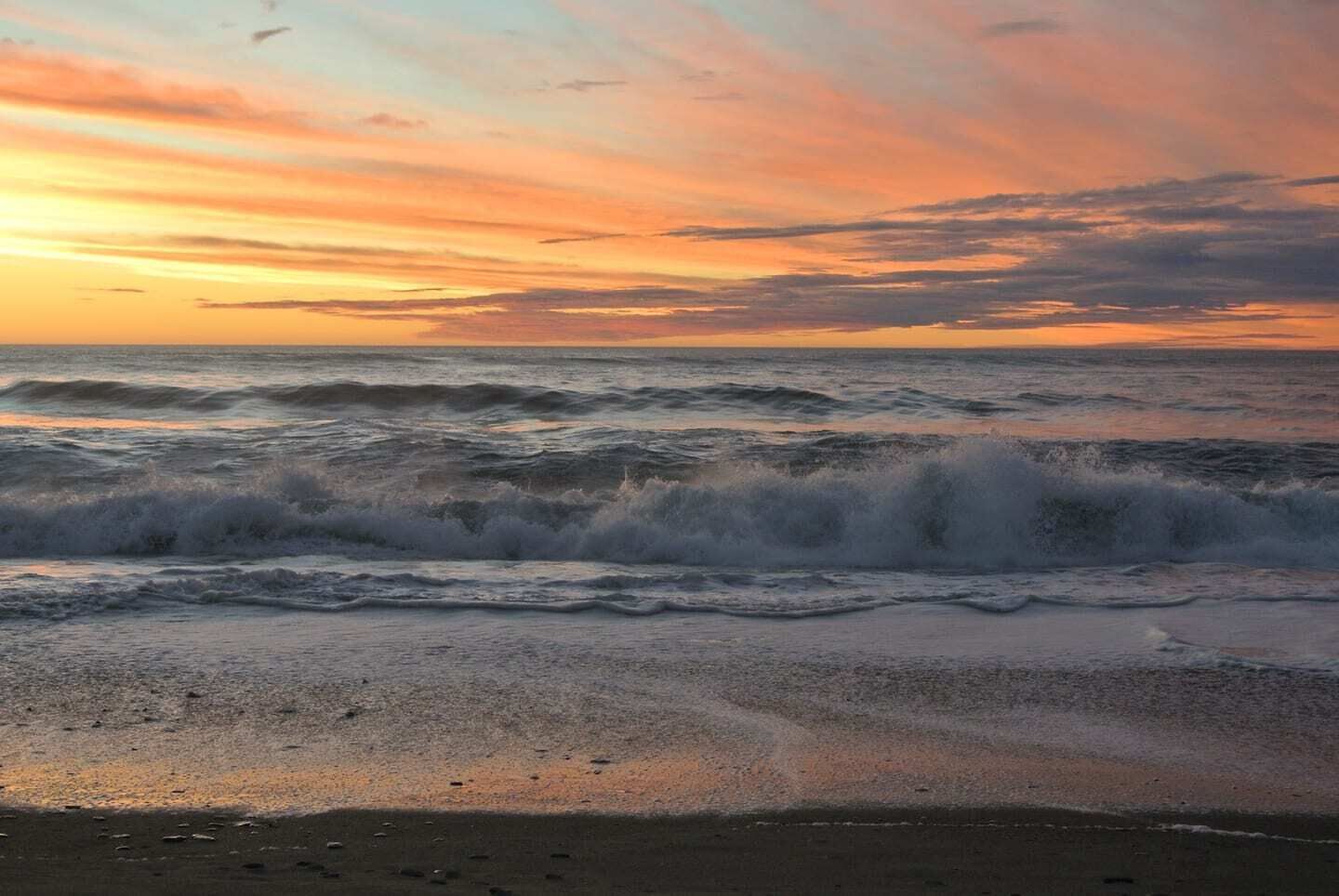 Una spiaggia con le onde al tramonto.