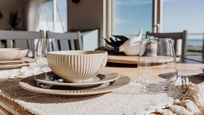 A dining table set with a bowl, plates, and a glass.