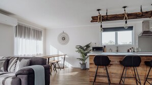 Una sala de estar moderna con un sofá, una mesa de comedor y una zona de cocina con barra.