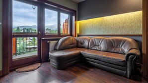 A corner sofa with a view of mountains through large windows.