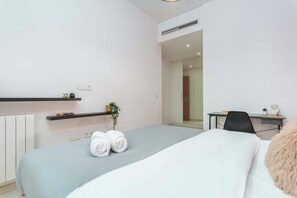 A modern hotel room with a bed, a desk, and a small plant. - Viva 3-BR Apt in Waterfront Dbayeh (Dbayeh)