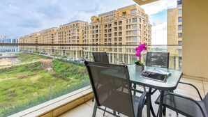 A balcony with a glass table, chairs, and a laptop. - Viva 3-BR Apt in Waterfront Dbayeh (Dbayeh)
