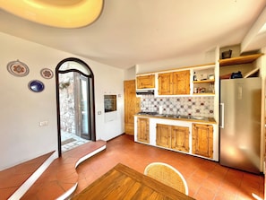 Eine kleine Küche mit Holzausstattung, einem eingebauten Herd und einem Kühlschrank.