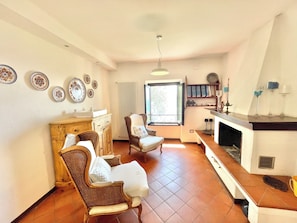 Ein Wohnzimmer mit Kamin, Essbereich und Küche.