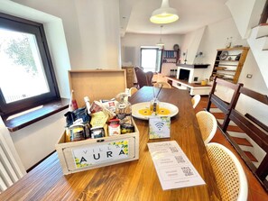A wooden dining table with a box labeled 'VILLA AURA LEMON GARDEN RETREAT' and a sign for 'LIMORA TRAVEL GUIDE.'