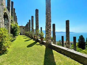 Ancient ruins with a grassy pathway and a view of the sea.