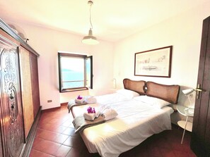 Una camera d'albergo con un letto, una finestra vista, una porta e un quadro appeso al muro.