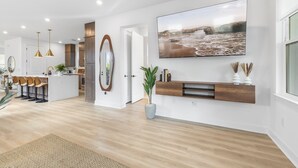 Een moderne keuken met een centraal eiland, houten kastjes en hanglampen.
