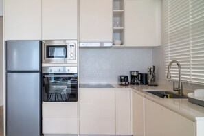 Departamento, balcón, vista al mar | Cocina privada | Refrigerador, microondas, horno y parrilla de estufa 