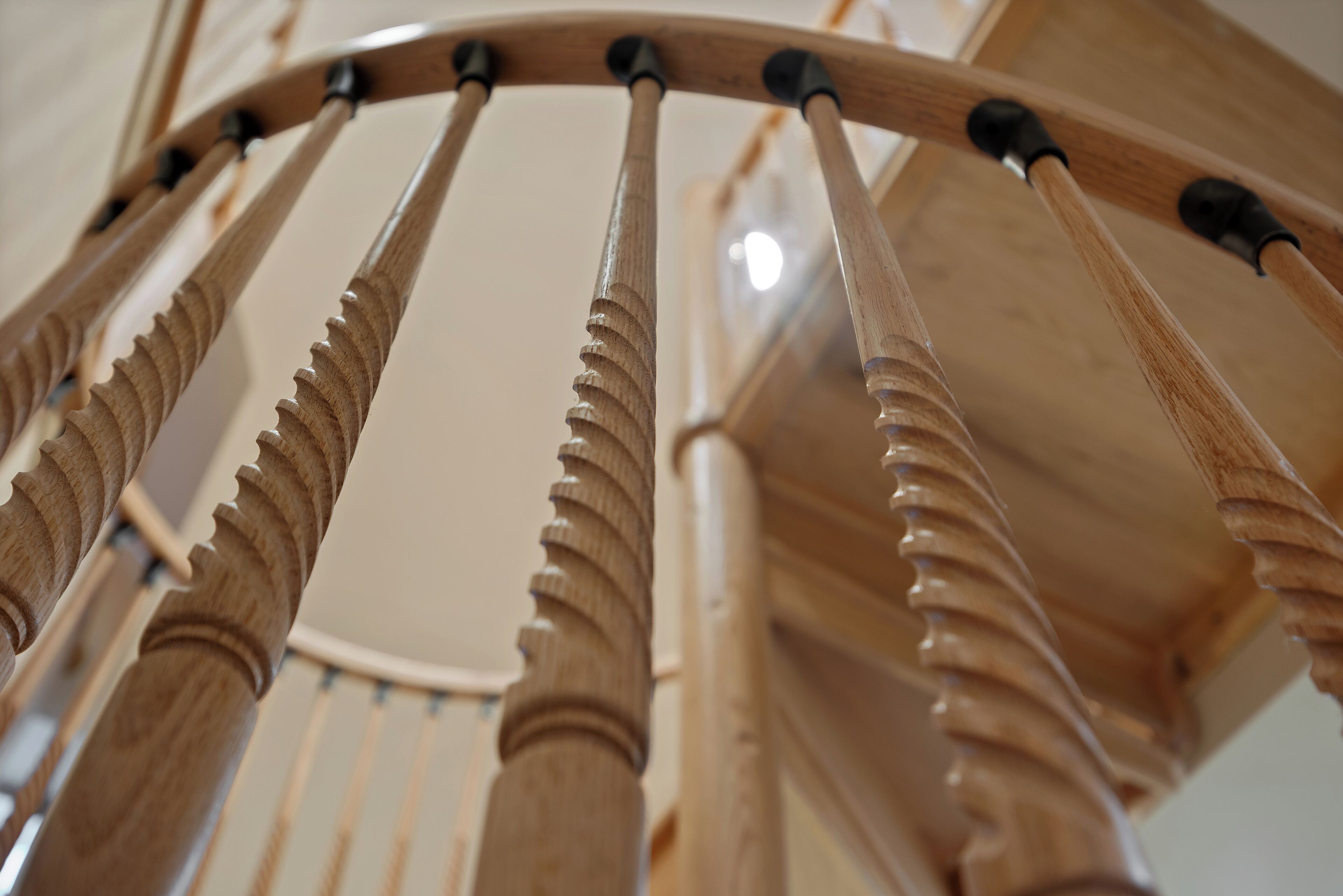 A close-up of a wooden chair with carved details and black metal supports.
