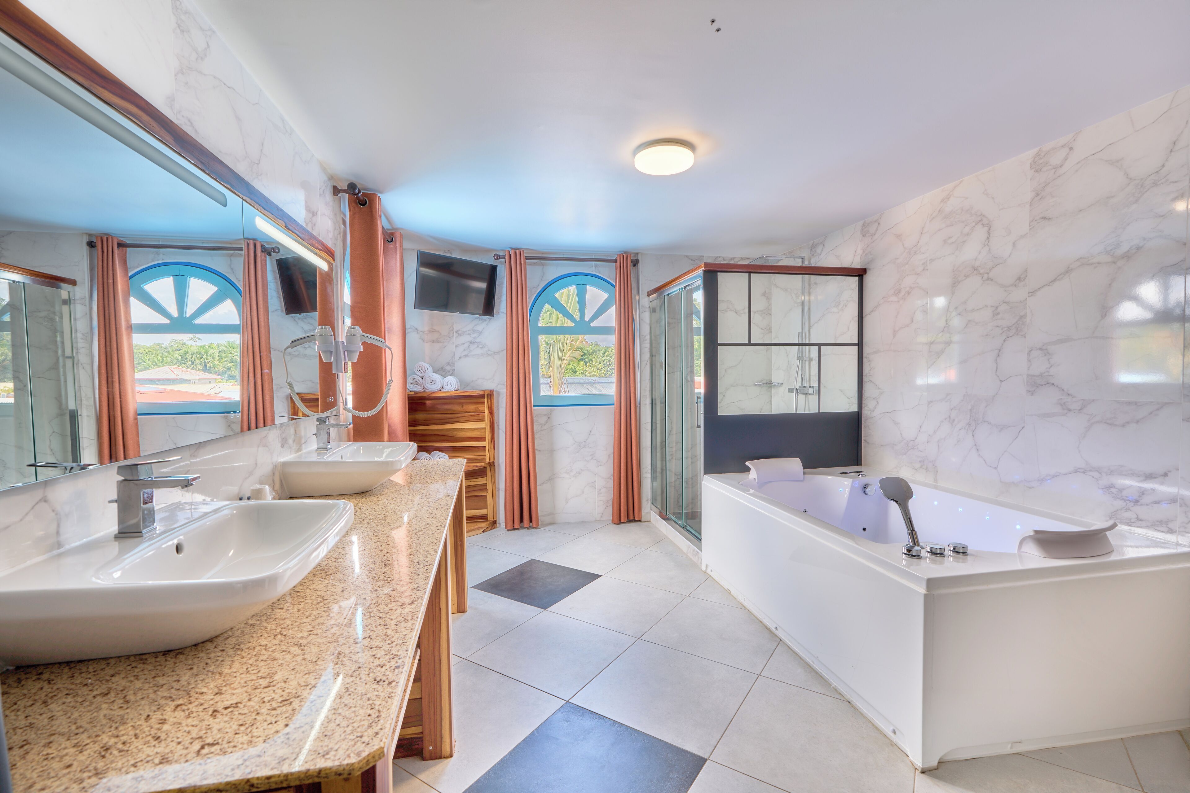A modern bathroom with two sinks, a bathtub, and a shower.