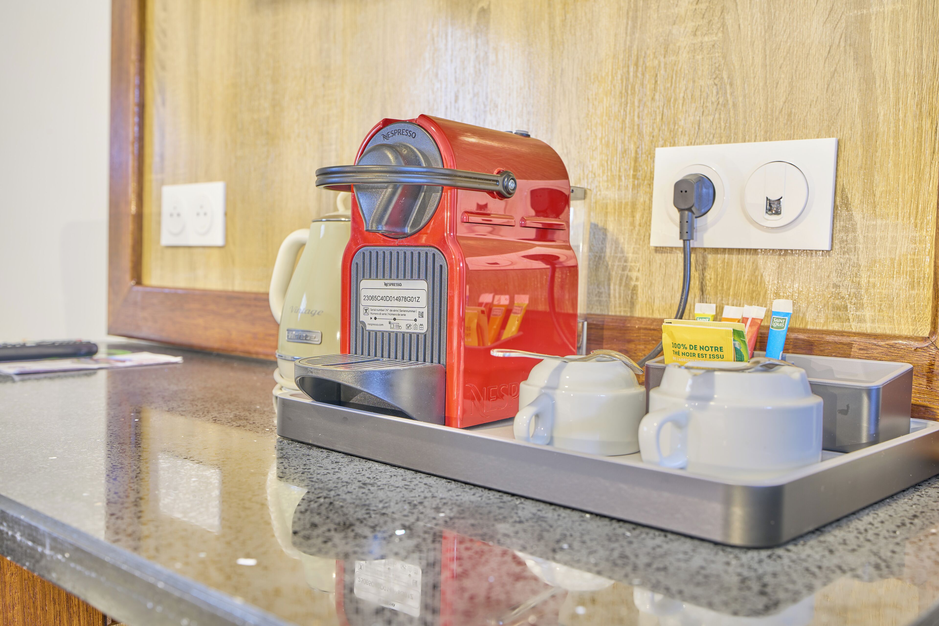 A coffee machine with a tray of cups and a coffee pot on a countertop.
