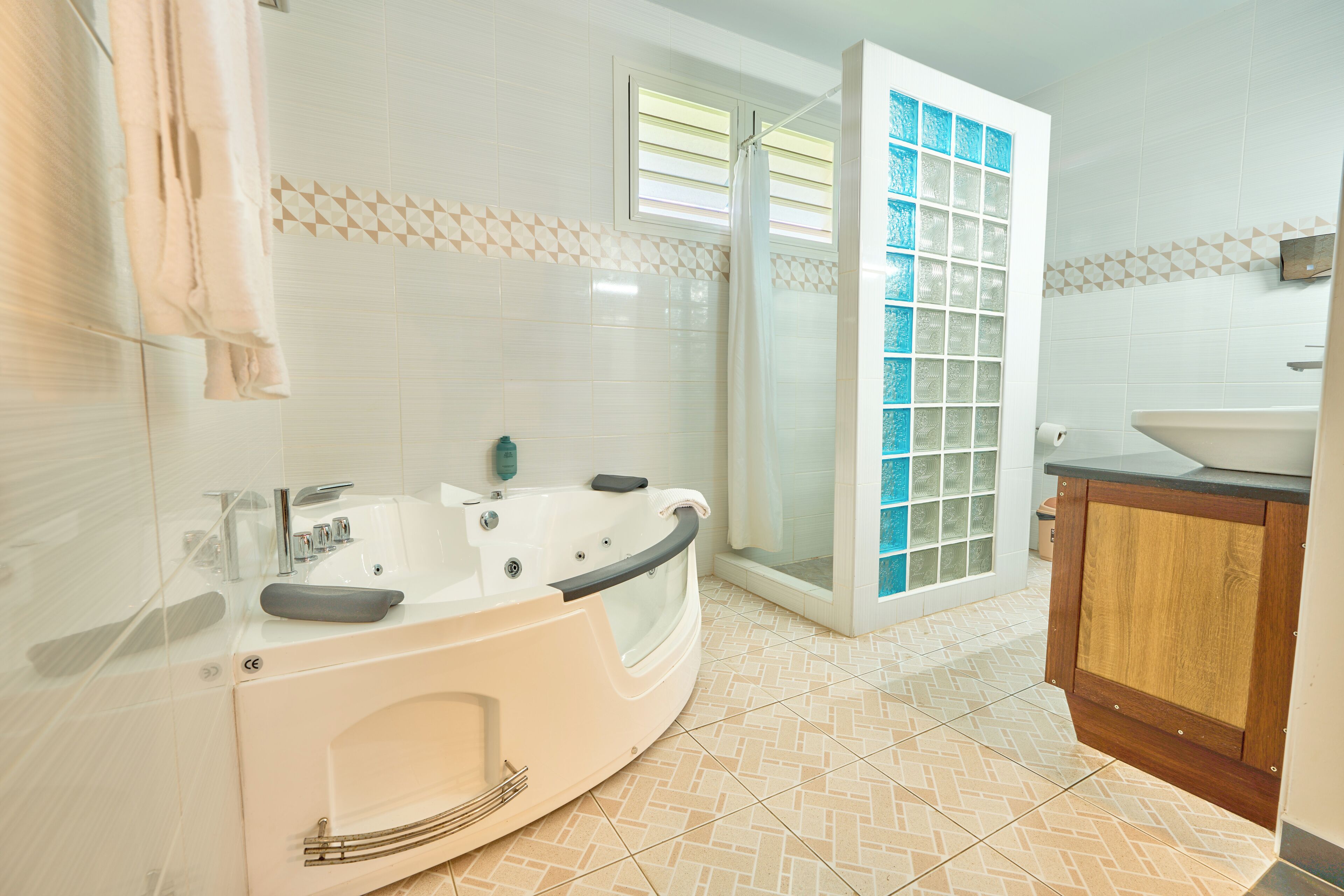 A modern bathroom with a freestanding bathtub, a glass shower enclosure, and a wooden vanity.